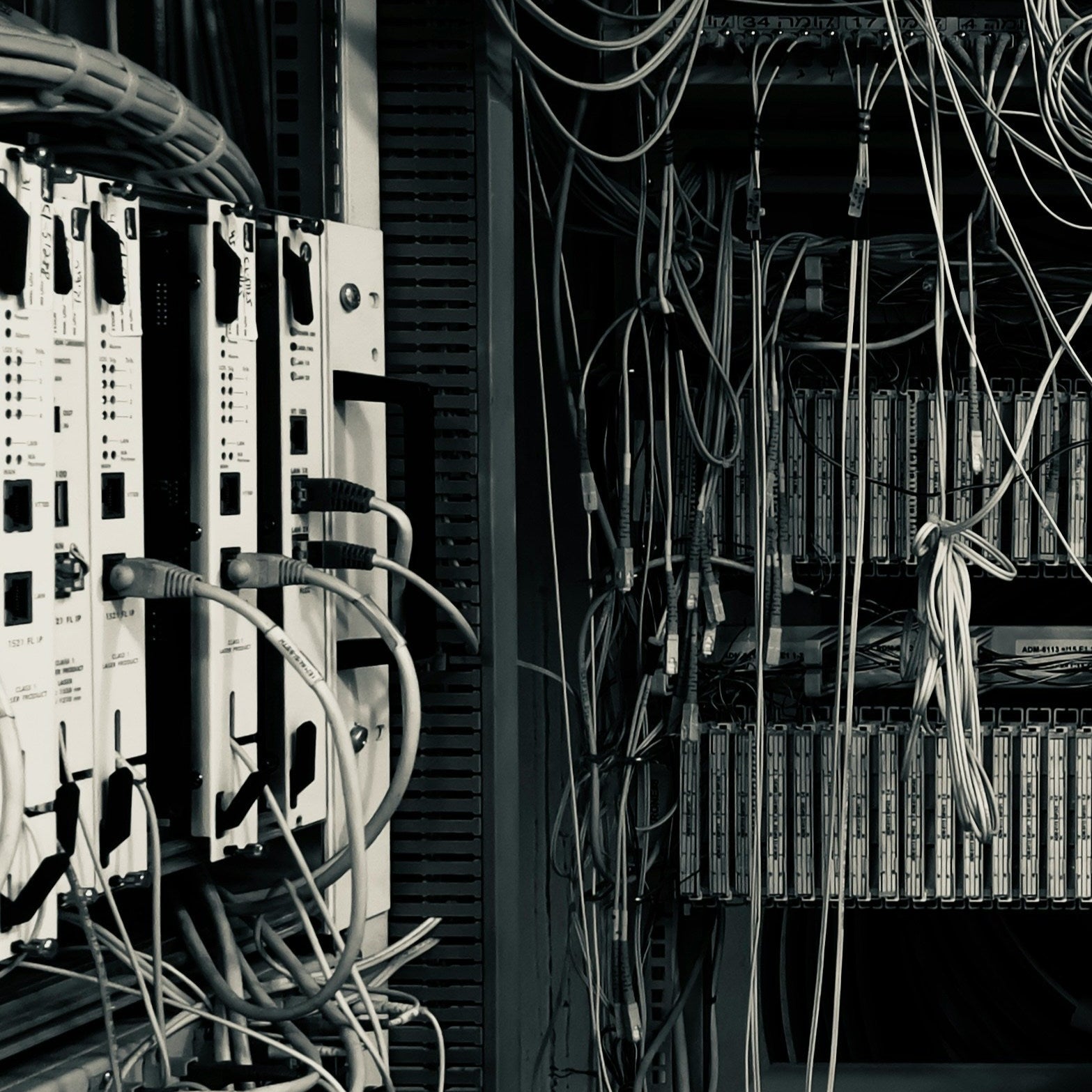 Complex network of cables and electronic equipment in a server room.